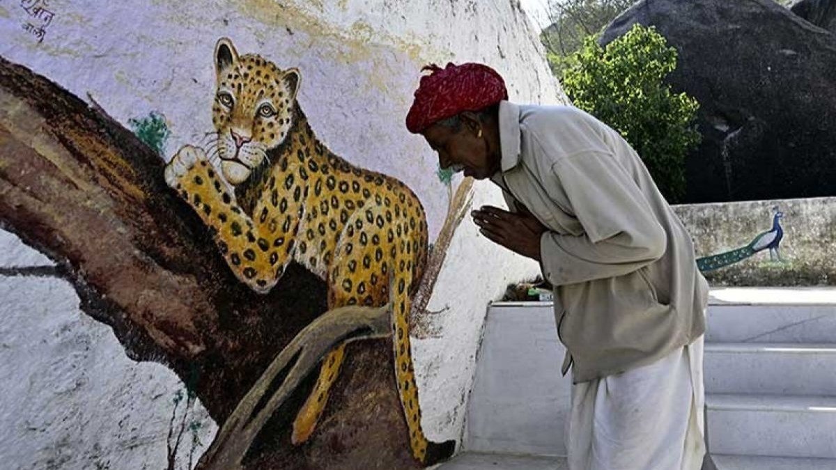 Rabari man praying to leopard mural